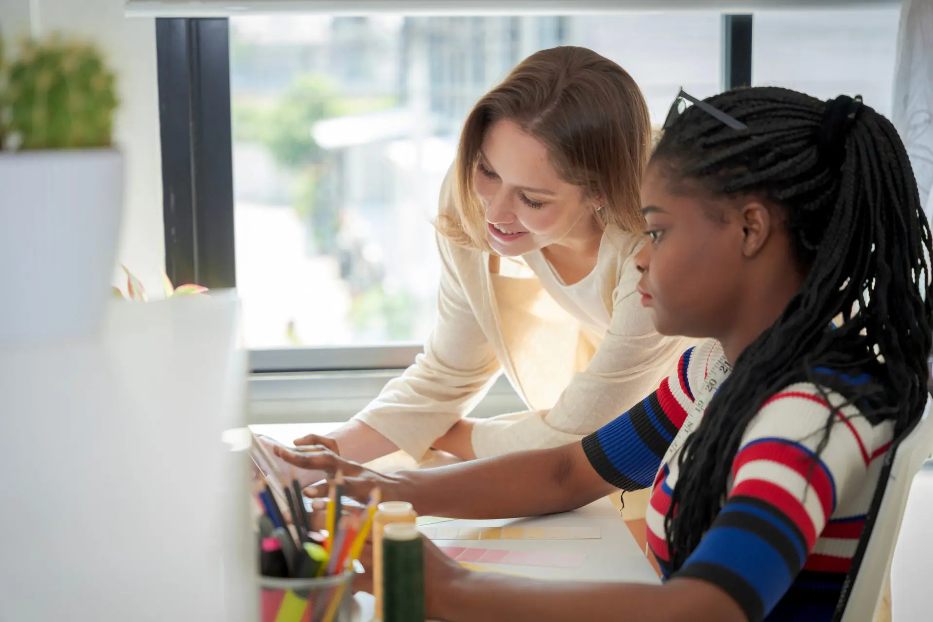 Special education teacher working one-on-one with a student in a classroom, providing personalized learning support.