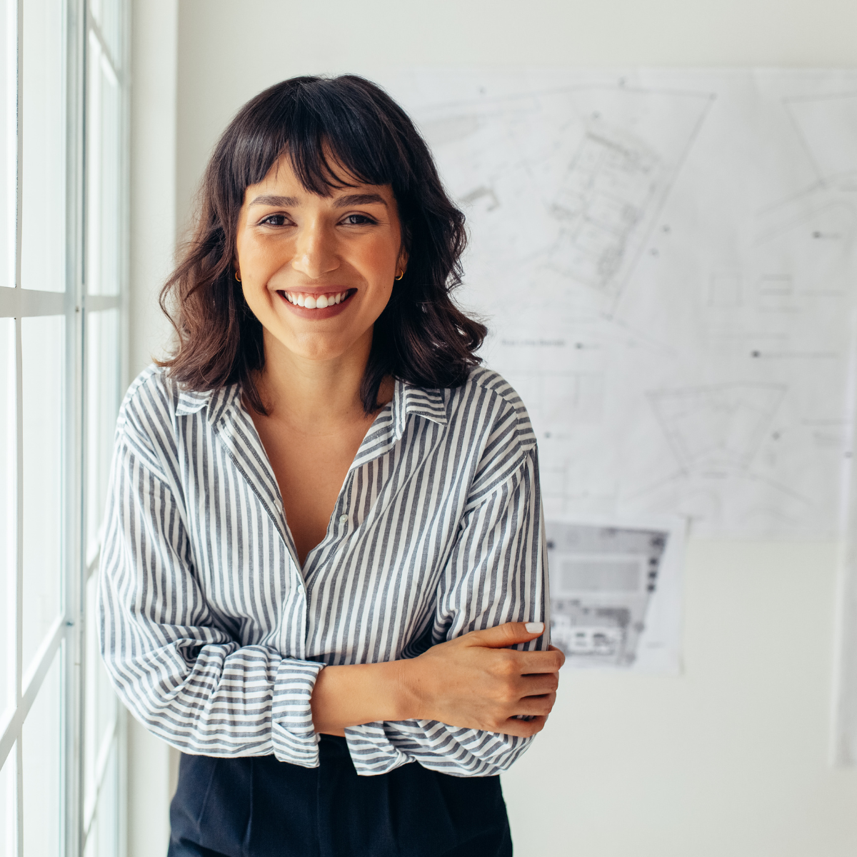 Smiling speech-language pathologist standing confidently in front of therapy plans, sharing her testimonial about career growth.