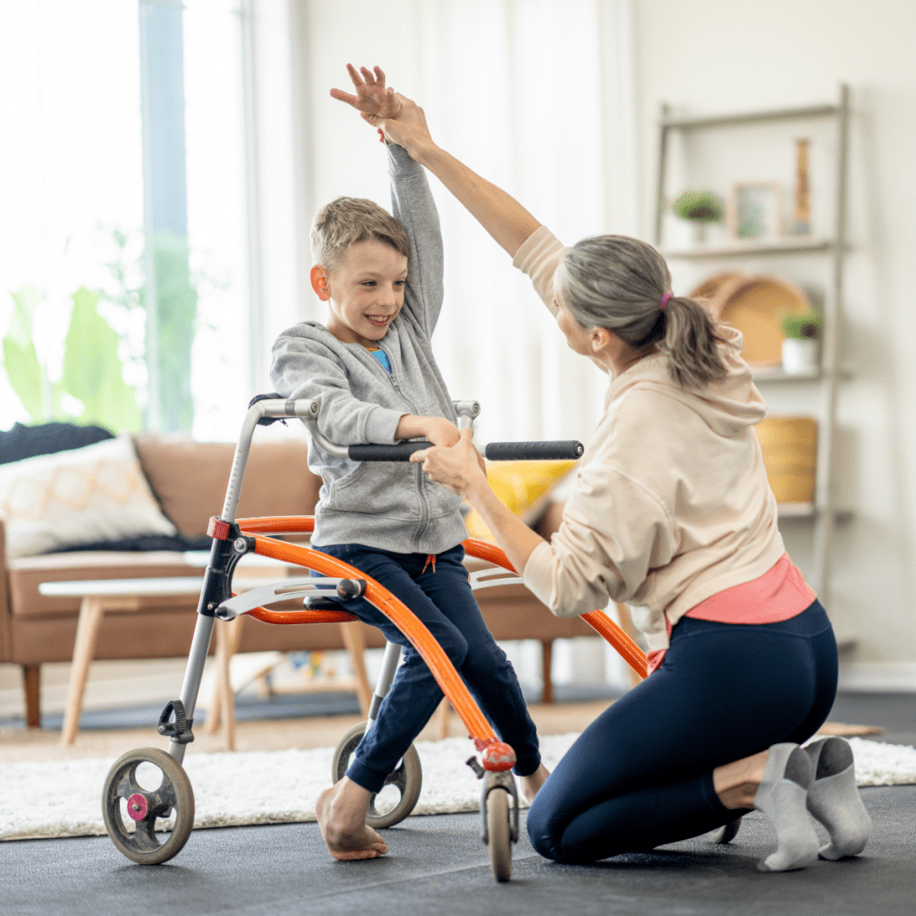 Therapy professional supports a child using a walker during a pediatric rehab exercise, encouraging balance and movement. 