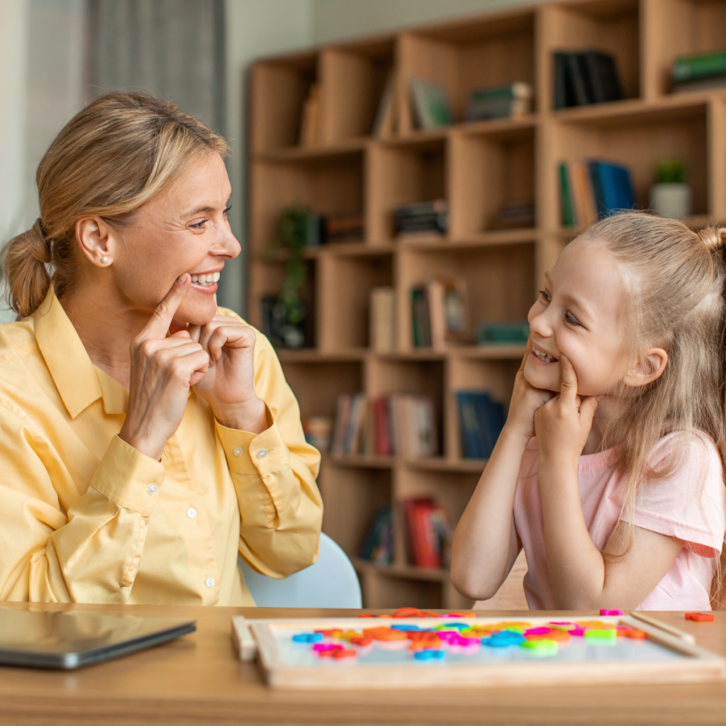 Speech-language pathologist works one-on-one with a child at a table, using visual activities to support communication skills. 