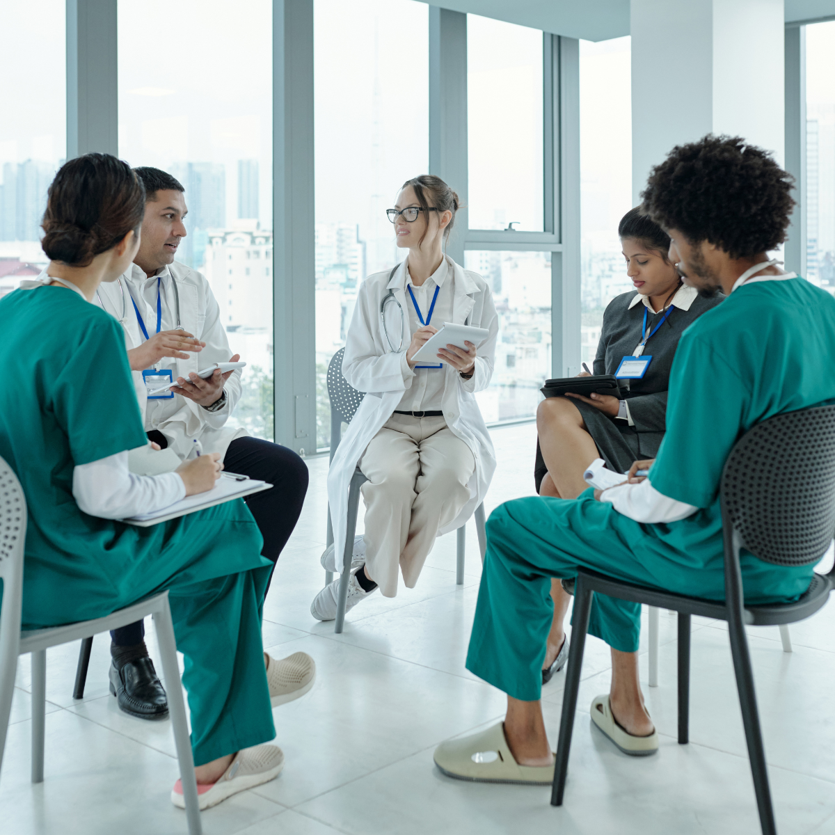 A diverse group of healthcare professionals and SLP students participating in a clinical round table discussion about patient care.