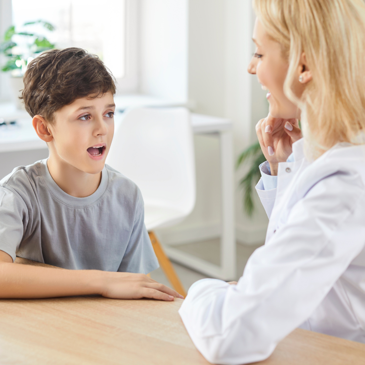 A speech-language pathology student and mentor in a bright clinical setting, reflecting the hands-on learning and intensive workload of SLP training.