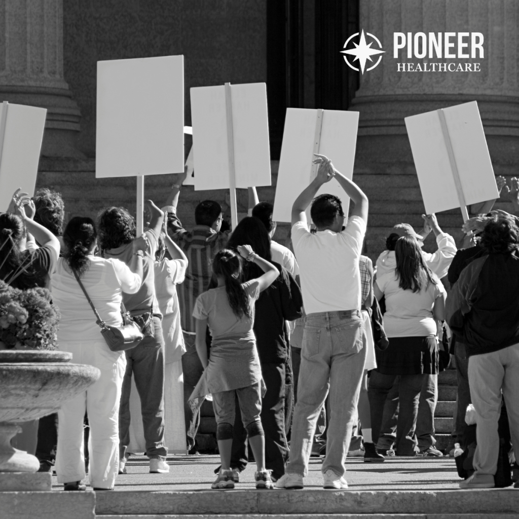 Healthcare workers holding blank protest signs during strike demonstration for safer staffing ratios and improved working conditions