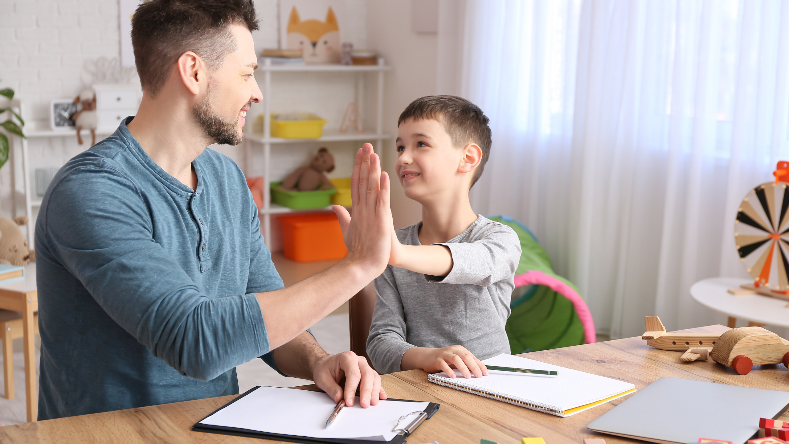Male psychologist working with little boy in the office.