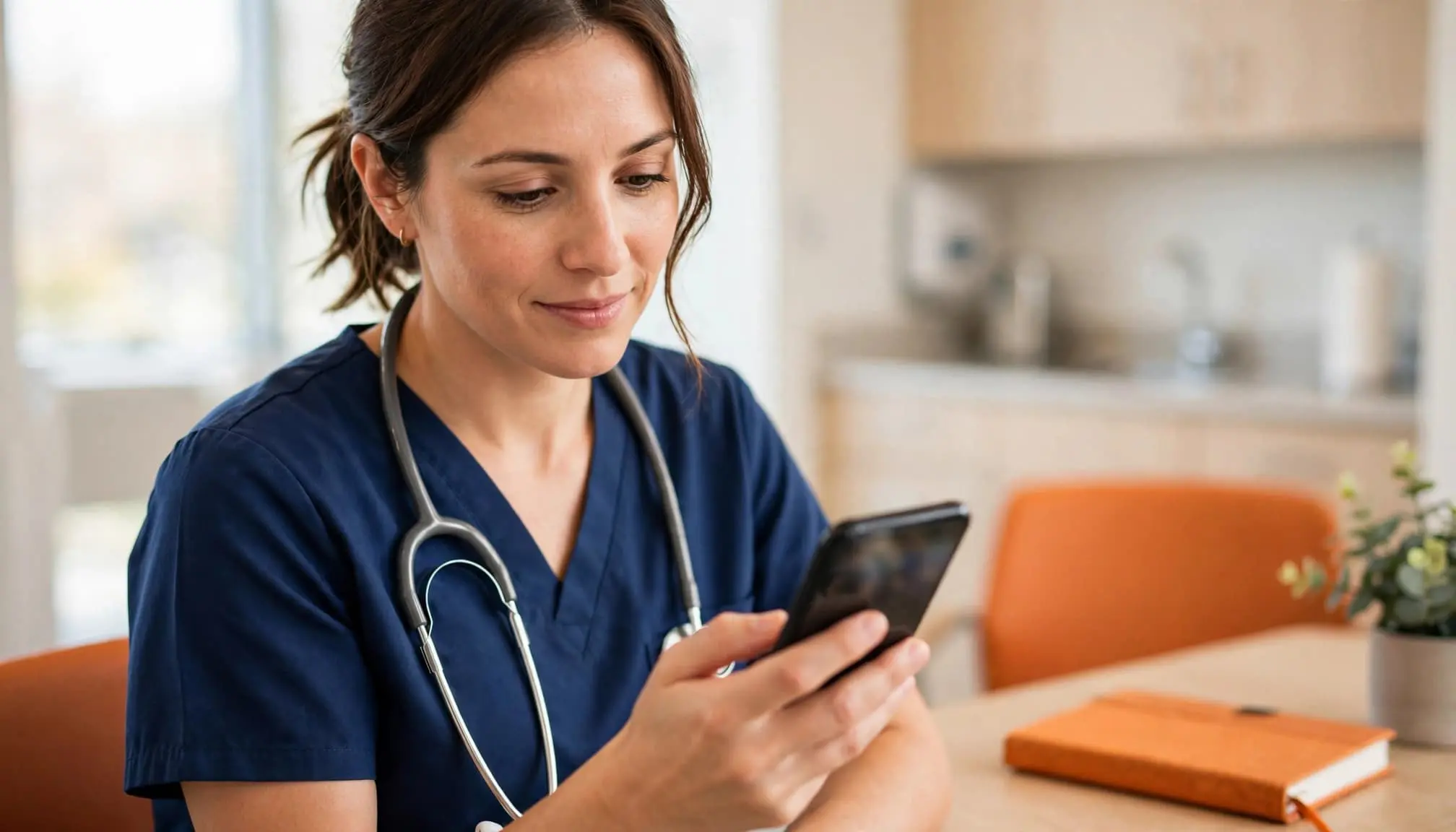 A clinician checks a smartphone in a bright hospital break area.